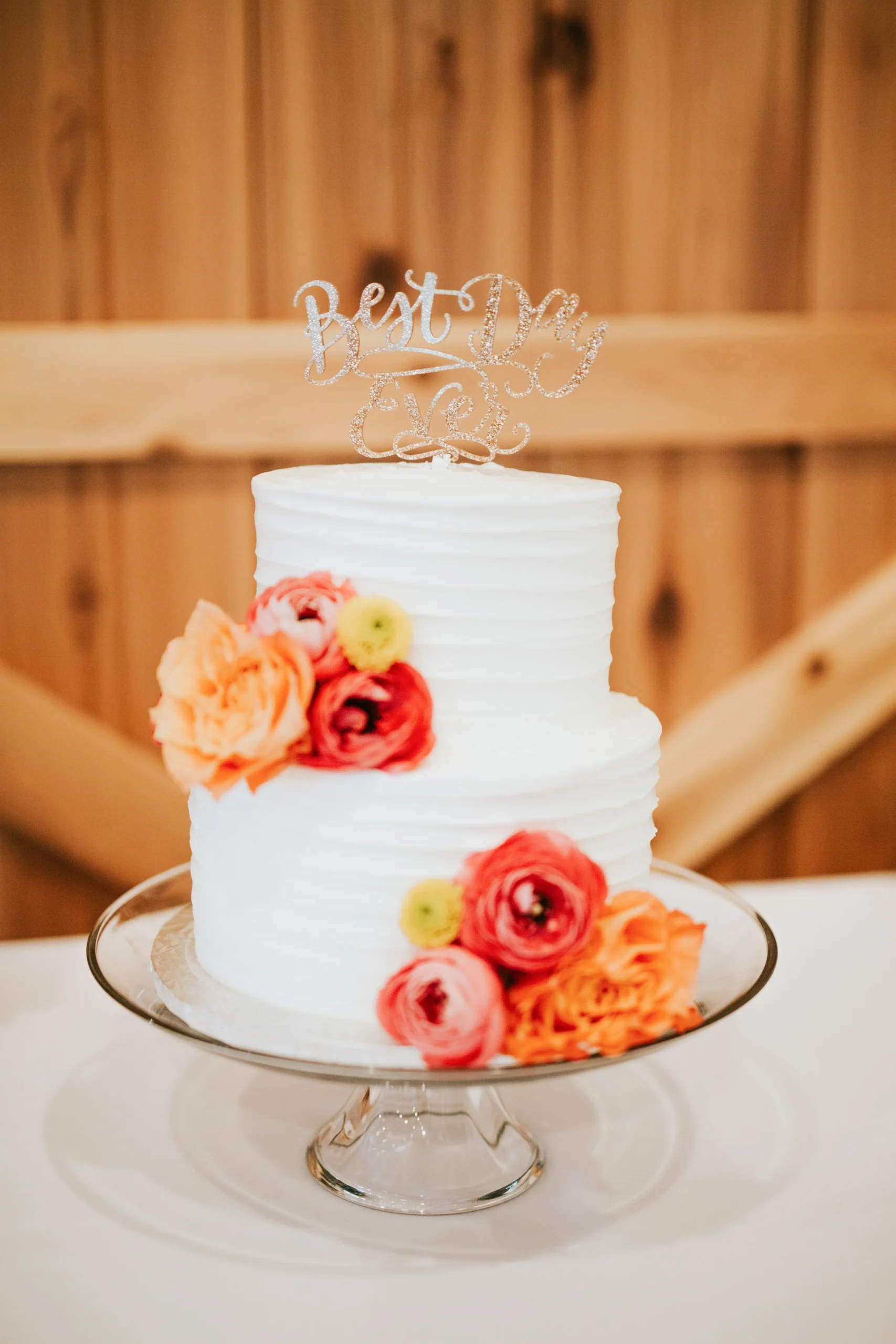 Simple white wedding cake with orange flowers